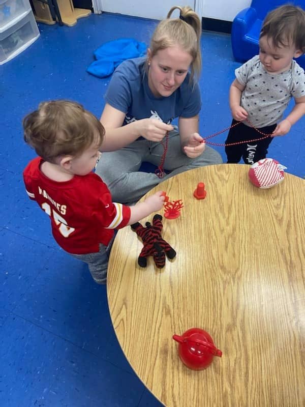 Educator with children at Mini Adventures Preschool in Warrensburg, MO engaging in a playful learning activity.