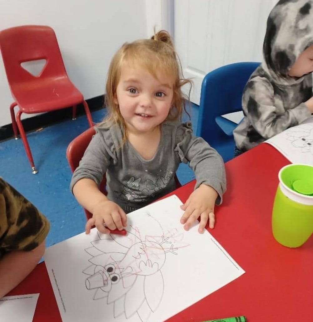 Child coloring a worksheet at Mini Adventures Preschool & Daycare in Warrensburg, MO.