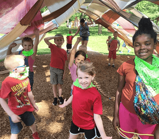 Children playing under a fabric canopy at Mini Adventures Preschool in Warrensburg, MO