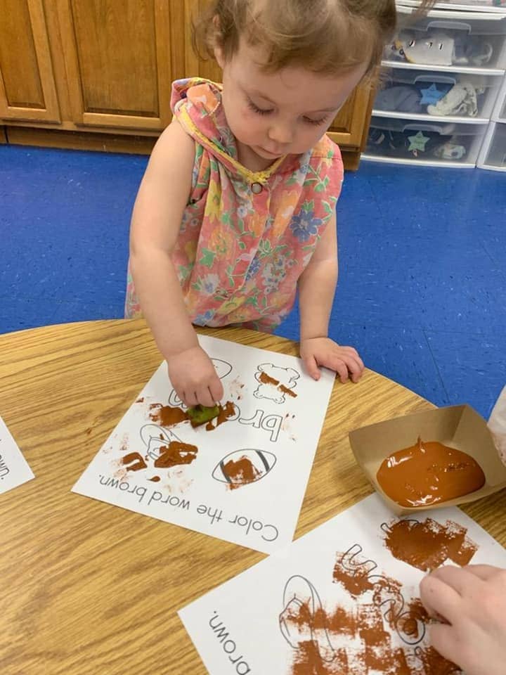 Infant engaging in Montessori-inspired art activity at daycare in Warrensburg, MO.