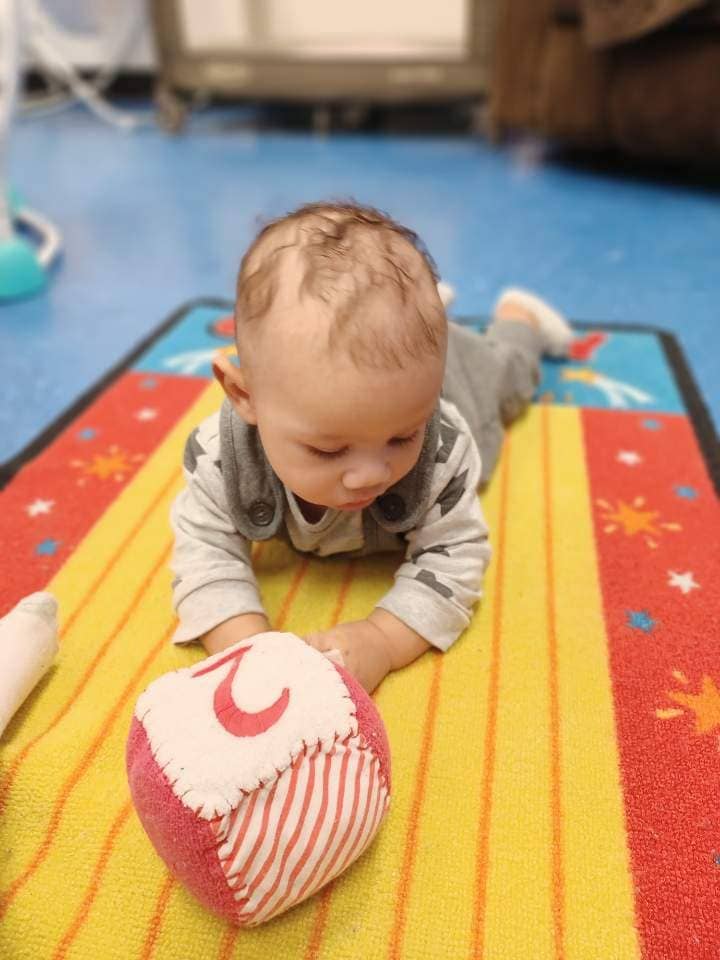Baby playing on a colorful mat at Montessori-inspired daycare in Warrensburg, MO.