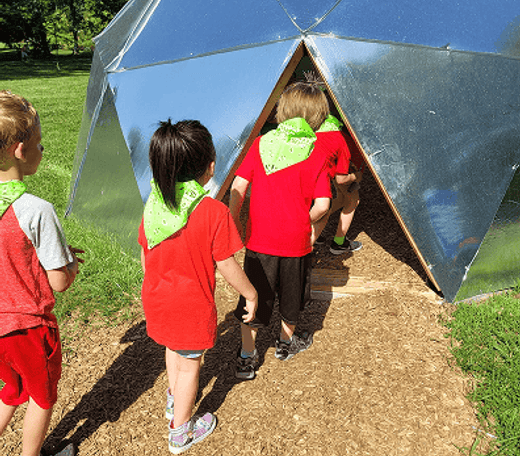 Children at Mini Adventures Preschool exploring outdoor dome in Warrensburg, MO.