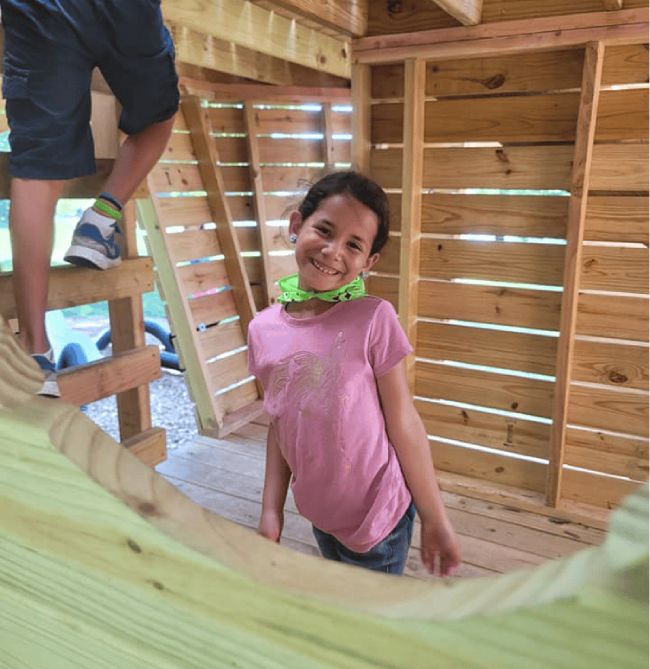 Two children in a Warrensburg preschool engaging in play-based learning with colorful crafts on the floor.
