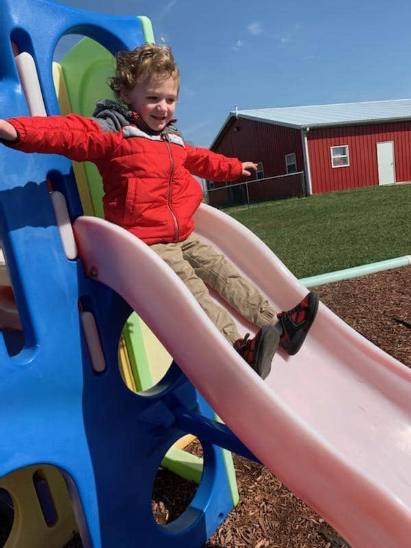 Child enjoying a slide at Warrensburg MO before and after school care program playground.
