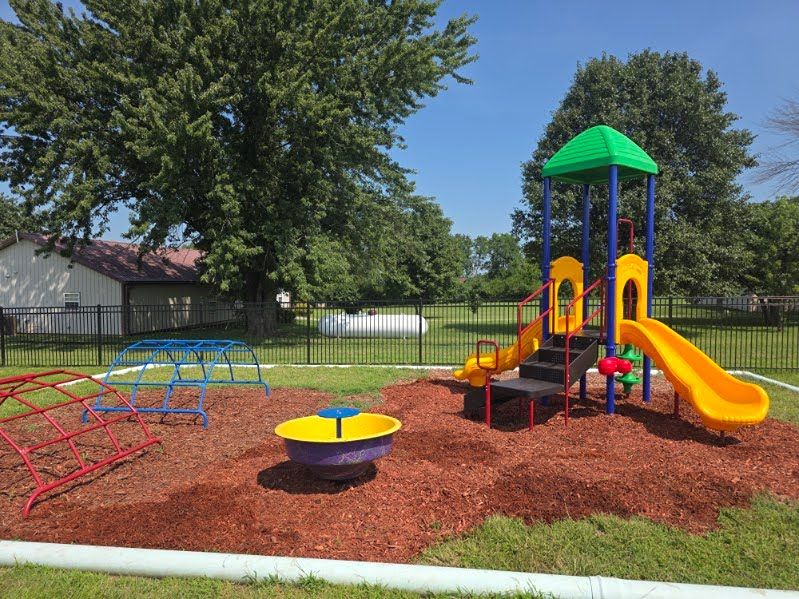Kids exploring outdoor play equipment at Mini Adventures Preschool in Warrensburg, MO.
