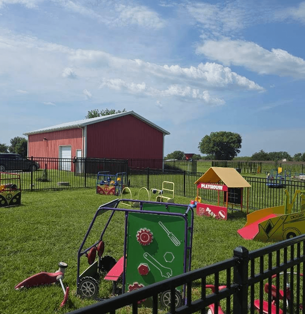 Children playing on Mini Adventures Preschool's spacious fenced playground in Warrensburg, MO.