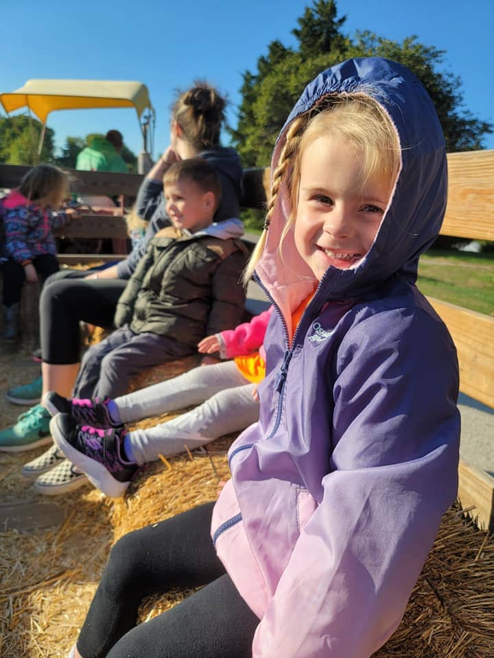 Children enjoying a hayride during a summer camp field trip in Warrensburg, MO.