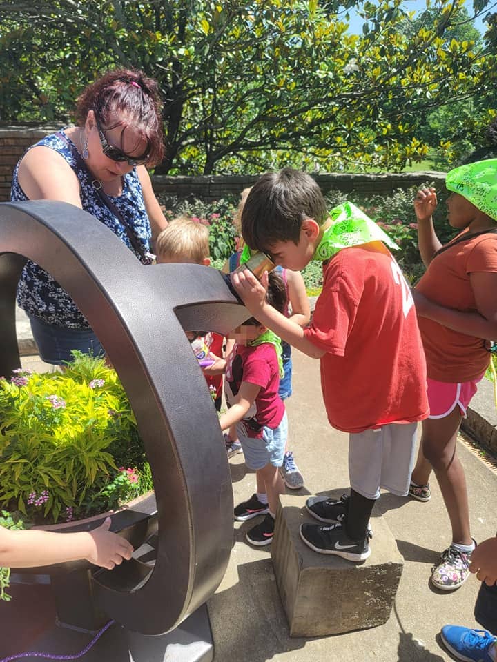 Children enjoying a nature-themed activity during a summer camp field trip in Warrensburg, MO.